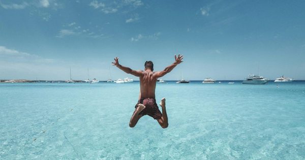 man jumping in ocean ibiza